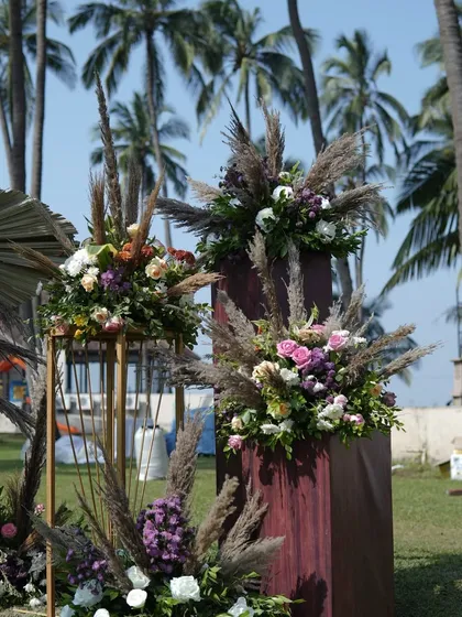 Floral arrangements for a tropical carnival, featuring a mix of pampas grass, roses, and other exotic blooms. This combination adds a touch of nature-inspired elegance to the vibrant event.