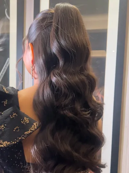 A detailed back view of the voluminous waves in this stunning high ponytail.