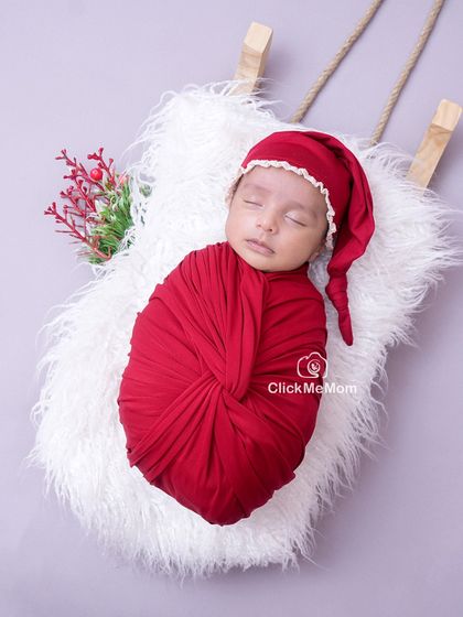 Another angle of our festive Christmas setup, showing the baby peacefully sleeping in a deep red swaddle, ready for their first holiday celebration.