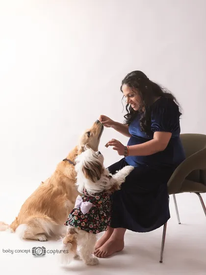 The color version of the same candid moment, showing the rich tones of the mother's dress and the dogs' coats. These interactive shots add a layer of authenticity to your maternity gallery.