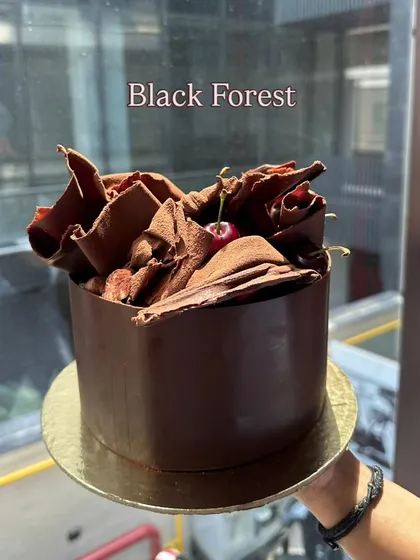 My modern take on the classic Black Forest cake. It features a rich chocolate collar, beautiful chocolate shavings, and a fresh cherry on top.