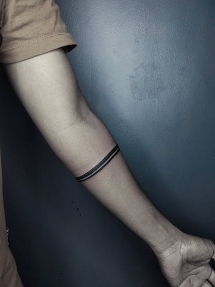 A close-up of the solid black double armband tattoo. The lines are crisp and evenly spaced, which is key for a clean look.