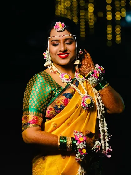 A candid moment of the bride adjusting her floral jhumka. Every piece is designed to be as beautiful as it is easy to wear throughout the festivities.