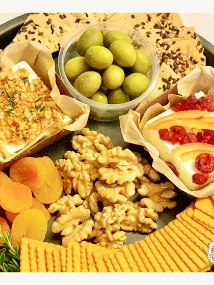 A cheese board perfect for a Sunday movie night. This platter includes feta cheese blocks, walnuts, olives, and dried apricots, offering a mix of savory and sweet bites.