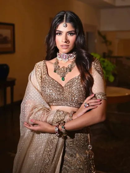 A confident pose in a golden lehenga. The styling highlights the intricate embroidery on the blouse and the elegant drape of the dupatta.