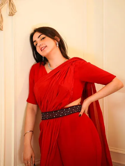 A close-up of the red Indo-western outfit, highlighting the embellished belt and the unique draping.