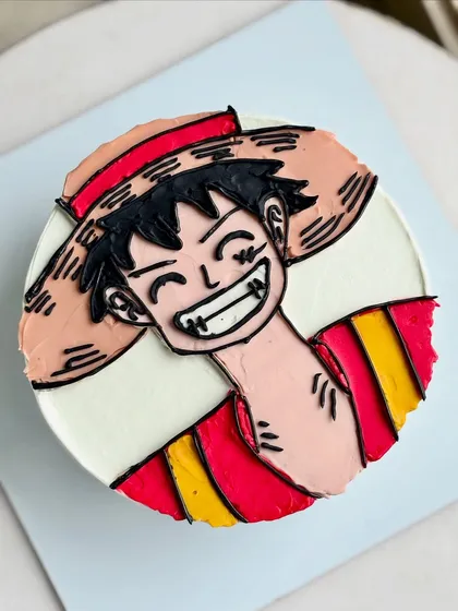 A top-down view of the Luffy cake, showing the clean lines and vibrant colors of the buttercream illustration.