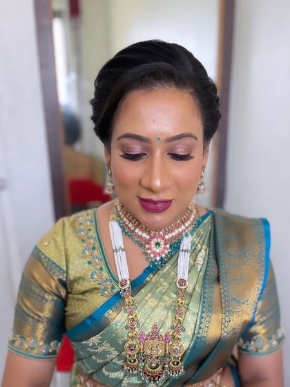 A sophisticated look for a wedding guest. The makeup is elegant and understated, with a focus on a classic winged liner and a deep berry lip.