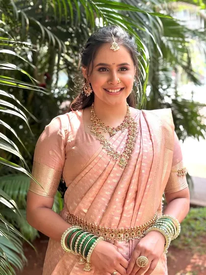 A full-length shot of my royal Maharashtrian bride in a beautiful pink Paithani saree. The makeup is soft and subtle, designed to complement her outfit and traditional jewelry for a stunning, unforgettable look.