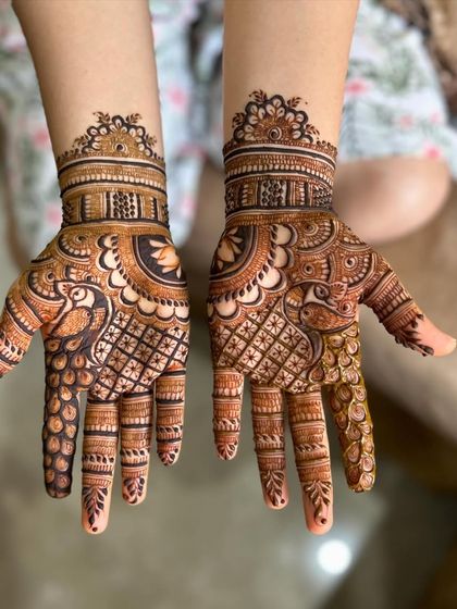 This design features graceful peacocks on the palms, surrounded by a mix of checkerboard and floral patterns. It's a full-hand design that is perfect for any festive occasion.