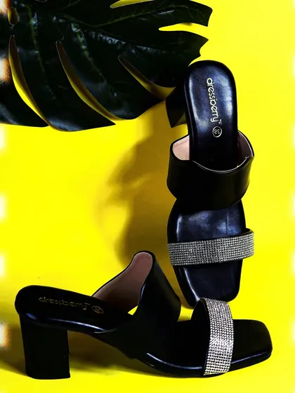 A creative composition of the Dressberry heels, using interesting angles and a large leaf prop to create a stylish and modern fashion photograph.