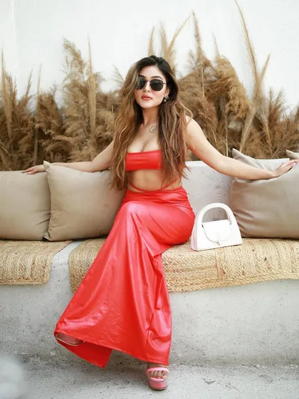 This on-location fashion shot for an influencer campaign uses natural light and a relaxed setting. The vibrant red outfit pops against the neutral background, creating a perfect look for social media content.