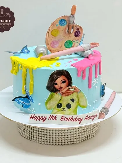 An art-themed cake customized from a Pinterest idea. This chocolate truffle cake features a colourful paint drip effect, an artist's palette, and brushes.