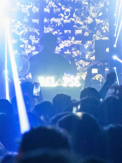 A silhouette against the lights at a packed house party event at Raahi. The energy was absolutely electric.
