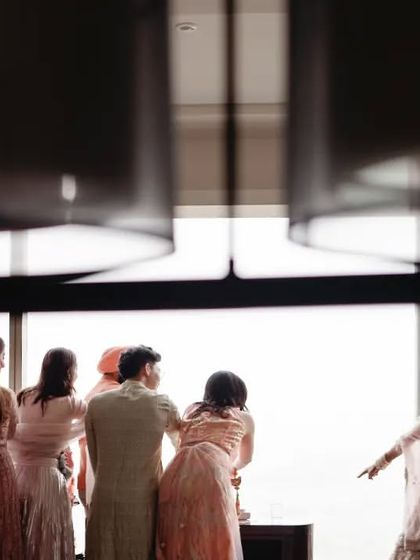 A candid moment of family looking out the window together. It's a quiet, observational shot that captures a moment of shared anticipation and togetherness.
