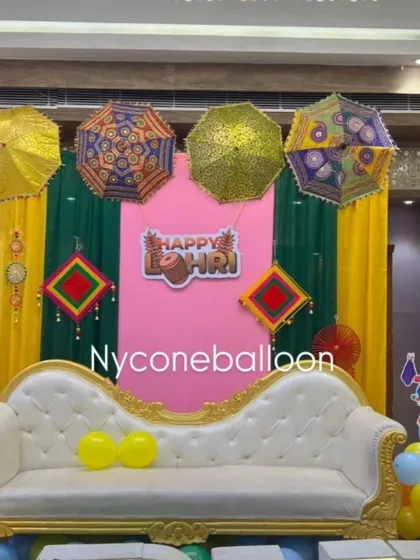 Here is a closer look at a Lohri stage backdrop I designed. The combination of a pink central panel, green and yellow drapes, and colorful Rajasthani umbrellas creates a rich and festive setting for family photos.