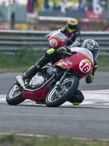 We train for all categories. Here, a rider skillfully navigates a corner on a retro-styled Royal Enfield Continental GT race bike during the JK Tyre GT Cup, showing the versatility of our coaching program.