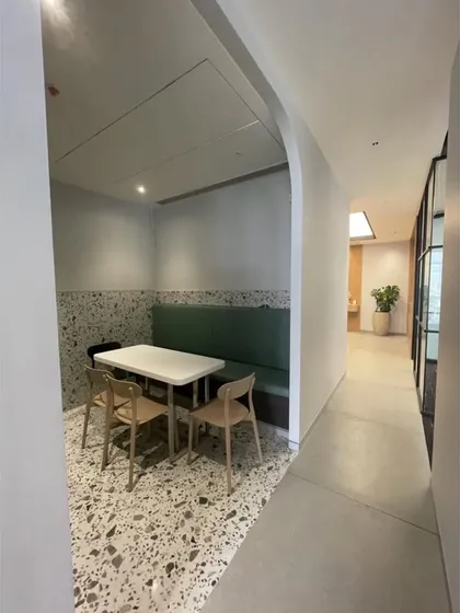 A small, semi-private breakout booth with a built-in upholstered bench. These nooks are strategically placed throughout our office to provide quiet spaces for focused work or small group discussions.