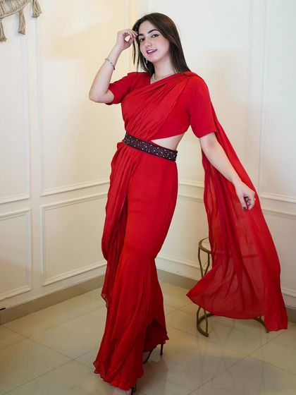 A full-length shot of a stunning red draped saree-style jumpsuit. This is a great example of modern Indo-western fusion wear that I love to style.