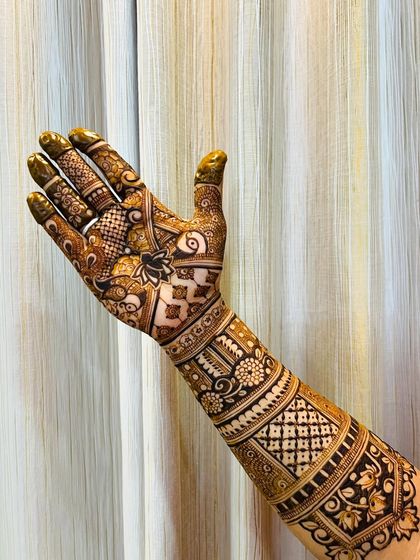 A stunning full-arm design with a mix of geometric and floral patterns, showing a beautiful golden-brown stain.