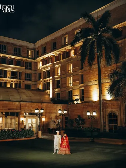 A wide-angle night shot of Devan and Shubhi outside the magnificent ITC Maratha. The warm lighting of the hotel creates a dramatic and luxurious backdrop for this couple portrait.