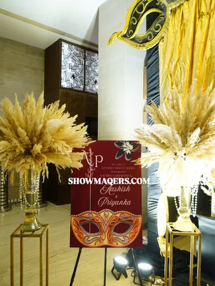 The welcome area for the masquerade Sangeet, featuring a custom sign and large arrangements of dried pampas grass.