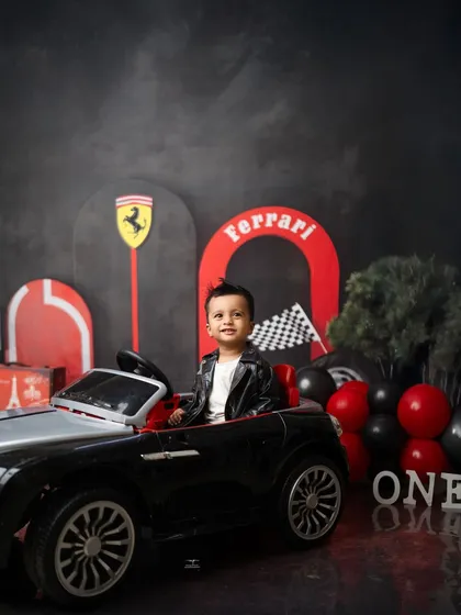 A happy smile from the driver's seat of his mini convertible. This Ferrari-themed first birthday shoot was full of cool details and happy moments.