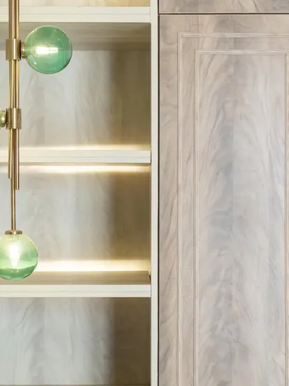 The green pendant light seen next to the light wood of the open shelving. This juxtaposition of color, material, and light is a hallmark of our detailed approach to design.