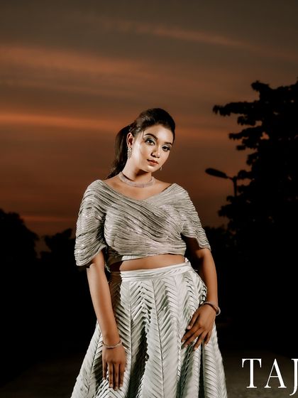 A stunning portrait of the bride taken just after sunset. The dramatic colors of the sky and the use of off-camera flash make her stand out beautifully against the dark background.