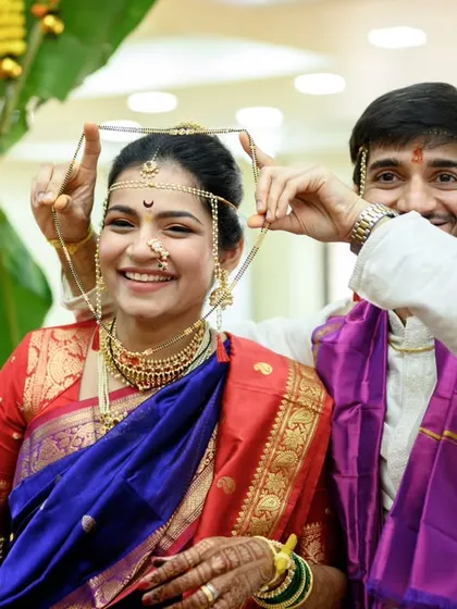 Success. The groom, Shubhankar, proudly displays the mangalsutra after successfully tying it. The bride's happy smile says it all. A fun, candid moment from their Maharashtrian wedding ceremony.