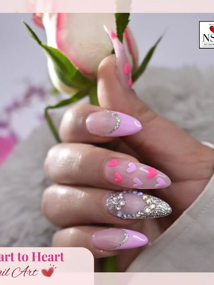 This sweet Valentine's look is all about love. It features a soft pink base with a French tip, an accent nail covered in sparkling crystals, and tiny pink and purple hearts scattered across the nails.