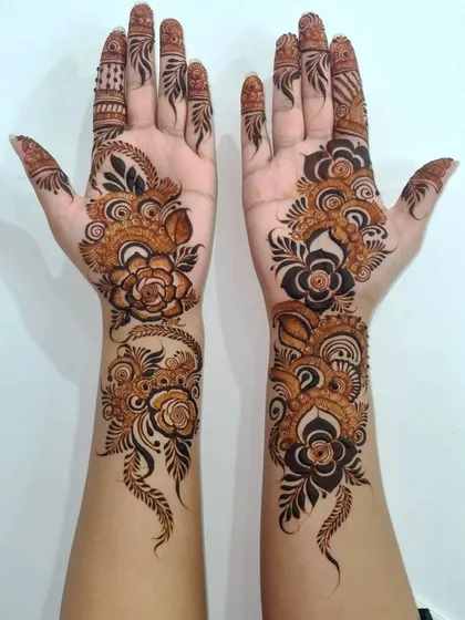 For a modern and bold statement, I love creating Arabic-style henna. This design features prominent floral vines that flow elegantly along the hands, leaving open space to make the pattern pop.