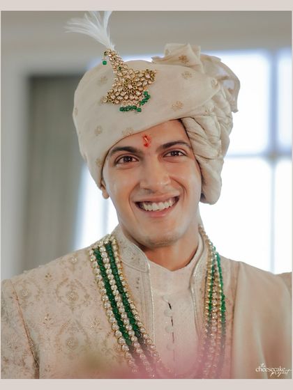 A handsome portrait of the groom, smiling brightly on his wedding day.