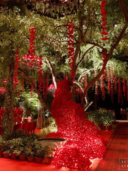 In 'Laal Bagh', I used florals to create dramatic, artistic installations. Here, a cascade of red flowers appears to flow from a tree, transforming the natural landscape into a whimsical part of the decor.
