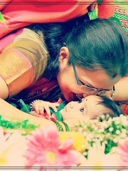 It is a blessing to witness these precious, tender moments. This close-up shot captures a mother's love as she adores her baby resting in a flower-decorated cradle during the naming ceremony.