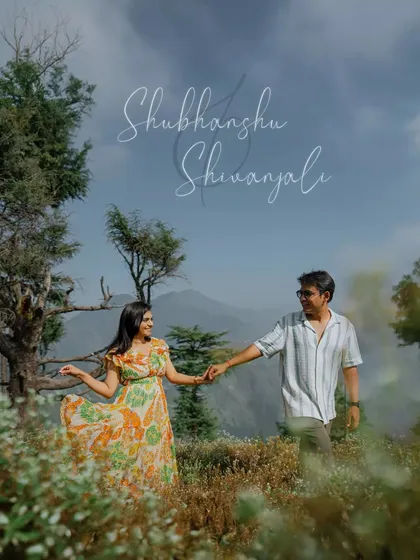A couple holds hands amidst a field of wildflowers in Mussoorie, with the mountains creating a stunning backdrop. This highlights our destination pre-wedding photography services.