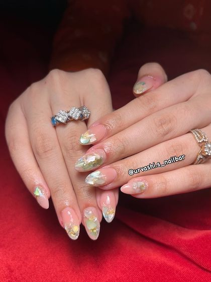 A delicate and ethereal look for a bride. This set features a soft, shimmery base with embedded iridescent flakes and gold leaf, creating a manicure that glows from within.