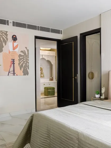 A quiet escape that speaks in subtleties. This view of the daughter's bedroom shows the vanity area with its arched mirror, the plush headboard, and the glimpse into the ensuite bathroom, creating a complete and serene suite.