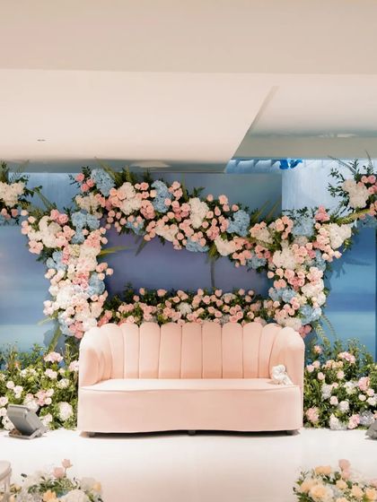 The full stage for the Roka ceremony, showcasing the beautiful arc of pastel flowers against the sky-blue background. The design is elegant, modern, and perfect for celebrating a new beginning.