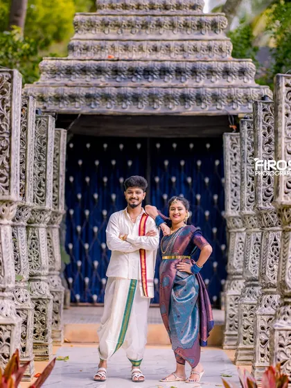 A stylish pose of a couple in traditional Kodava attire in front of our stone pillar set.