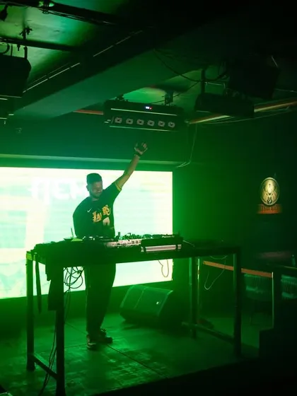 A full-stage view at Cyclone Club, with me commanding the audience under bright green lights.