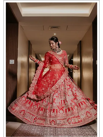 A stunning full-length shot of the bride twirling in her red lehenga, a classic and beautiful bridal portrait. This is the same as 60 but good to have in this cluster.