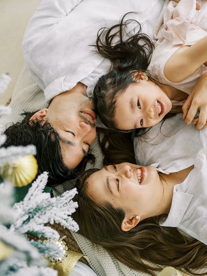 A family lying on the floor, heads together, smiling. A fun and creative angle for a holiday portrait.