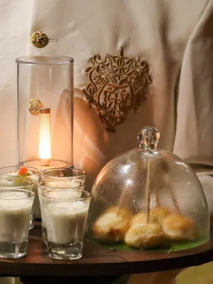 An experience in a single tray. Our server presents Dahi Golgappas under a glass cloche alongside refreshing shots, a modern and theatrical way to serve a classic.