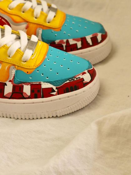 A detail of the toe box on the multi-color drip AF1s. The design even includes a painted cityscape, adding another layer of artistry to the shoe.