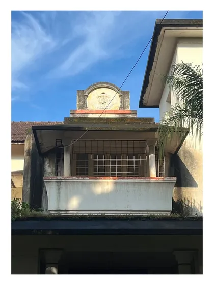 A detail of the building's crest and balcony. The project requires a sensitive approach to preserving original details while upgrading the structure for contemporary use.