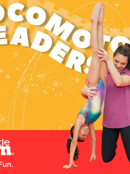 A young gymnast practices a handstand with the help of her instructor. This one-on-one coaching helps children master complex movements safely, turning them into confident 'Locomotor Leaders'.