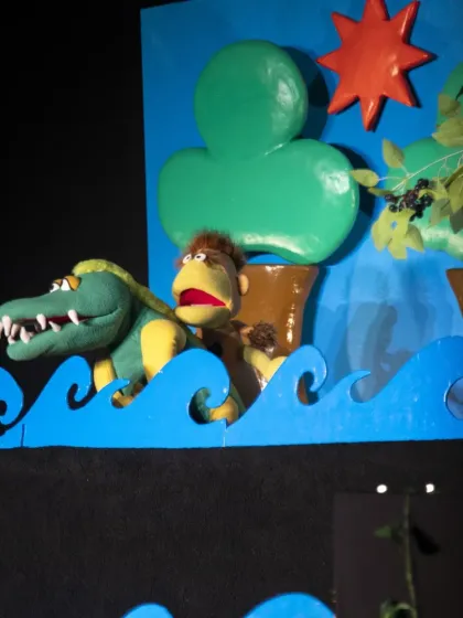 The monkey and crocodile together on the river. The performance uses simple but effective puppetry to tell a timeless story of friendship and betrayal.