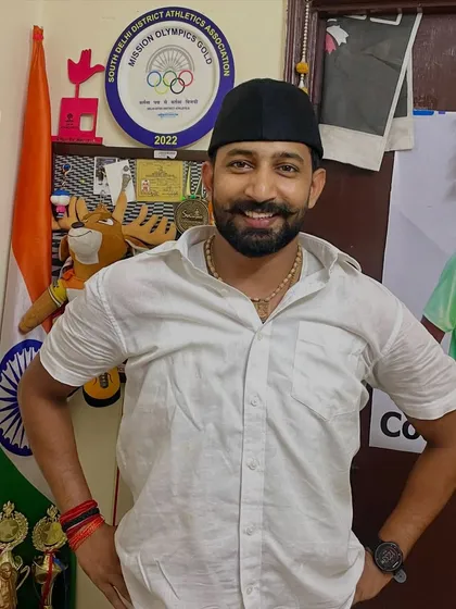 Another photo from my home, with the Indian flag and my athletes' awards in the background. My love for my country and my passion for coaching are intertwined.