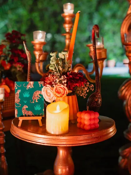 A close-up of a side table arrangement, featuring a unique bubble candle, a mini art piece with a tiger motif, and elegant candle holders. Every corner is thoughtfully styled.